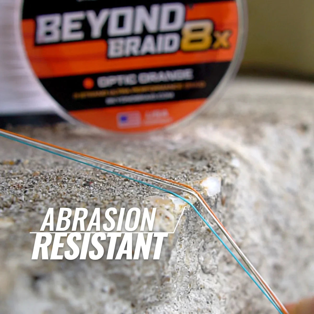 Fishing line with &#39;Beyond Braid 8x&#39; label and abrasion resistant text on a concrete surface.